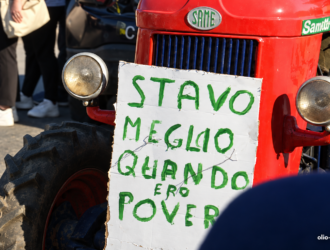 Trattore rosso con cartello di protesta