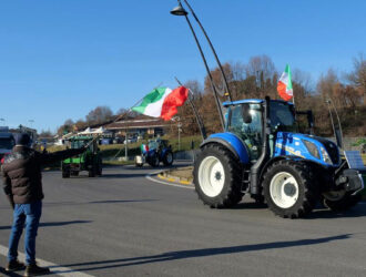 Trattori con bandiere italiane durante una manifestazione di protesta degli agricoltori.
